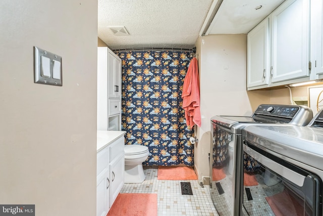 washroom with washing machine and clothes dryer and a textured ceiling