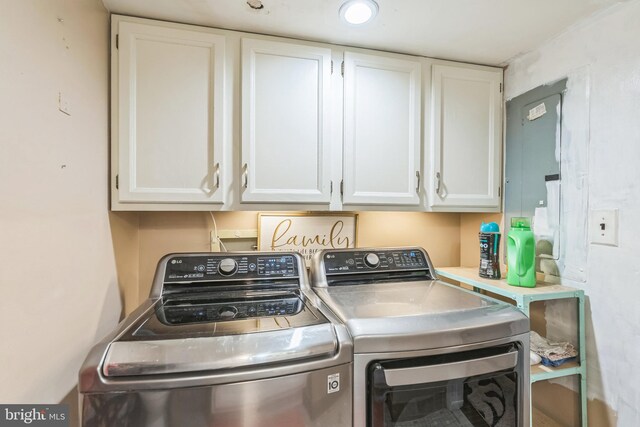 washroom featuring electric panel, cabinets, and washer and dryer