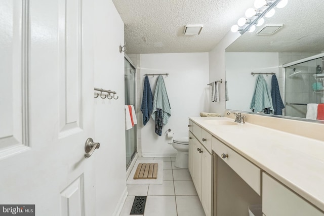 bathroom featuring tile patterned floors, walk in shower, vanity, a textured ceiling, and toilet