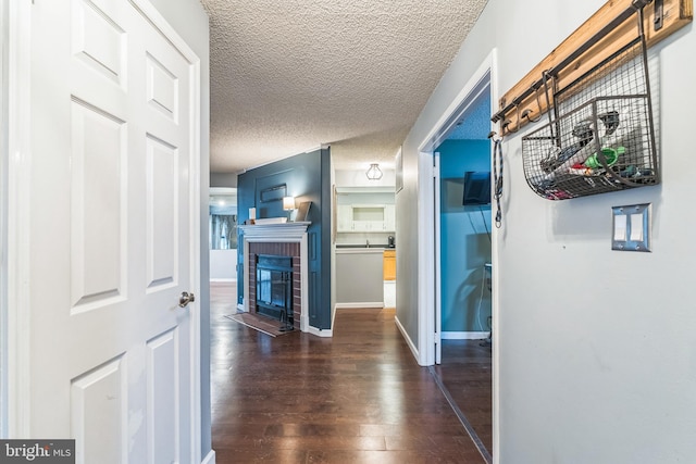 hall with dark wood-type flooring and a textured ceiling