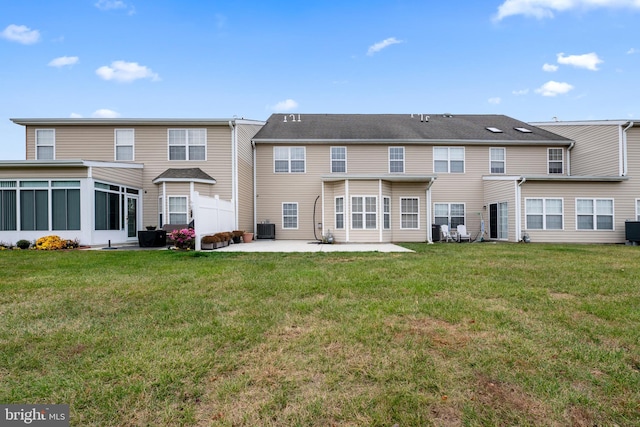 back of property featuring a sunroom, central air condition unit, a patio, and a yard