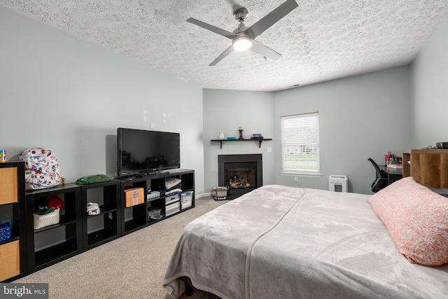 bedroom featuring carpet flooring, ceiling fan, and a textured ceiling