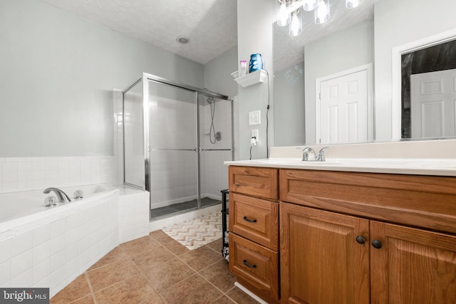 bathroom with tile patterned flooring, vanity, a textured ceiling, and independent shower and bath