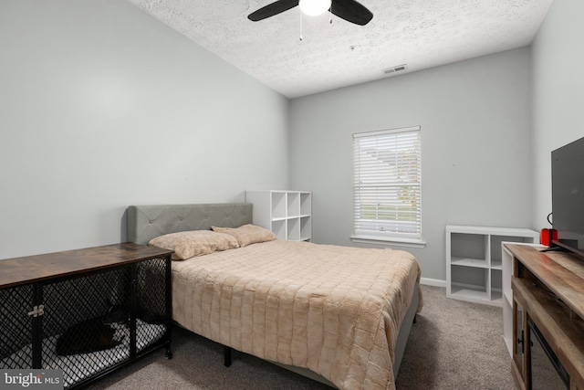 bedroom with ceiling fan, carpet floors, and a textured ceiling