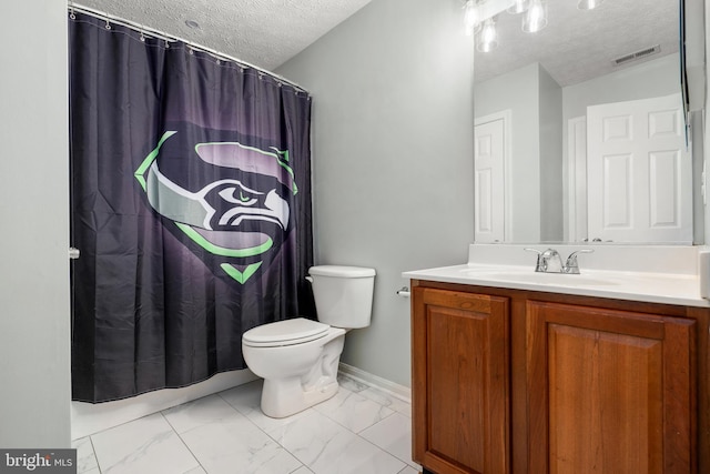 bathroom with toilet, vanity, and a textured ceiling