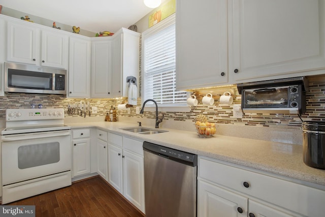 kitchen featuring appliances with stainless steel finishes, white cabinets, tasteful backsplash, and sink