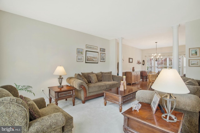 living room with ornate columns, an inviting chandelier, and carpet floors