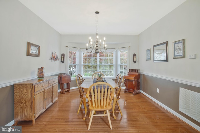 dining area featuring a chandelier and light wood-type flooring