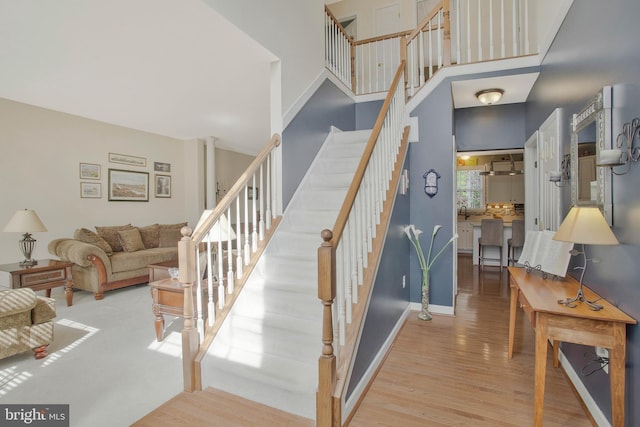 staircase featuring hardwood / wood-style floors and a high ceiling