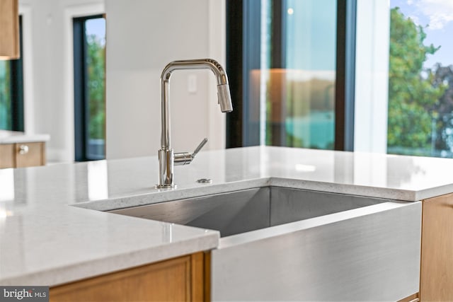 room details with brown cabinets, light countertops, and a sink