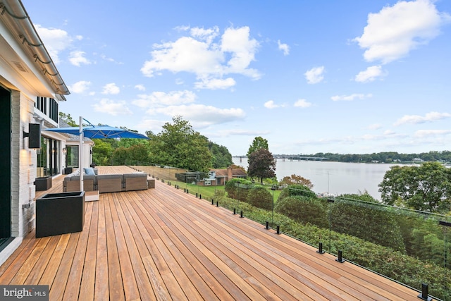 deck featuring an outdoor living space and a water view