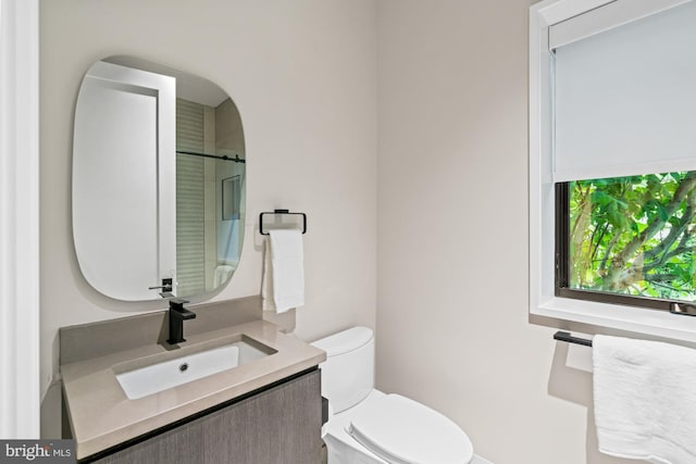 bathroom with vanity, toilet, and walk in shower