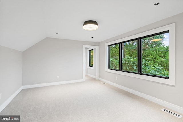 bonus room featuring visible vents, baseboards, light colored carpet, and lofted ceiling