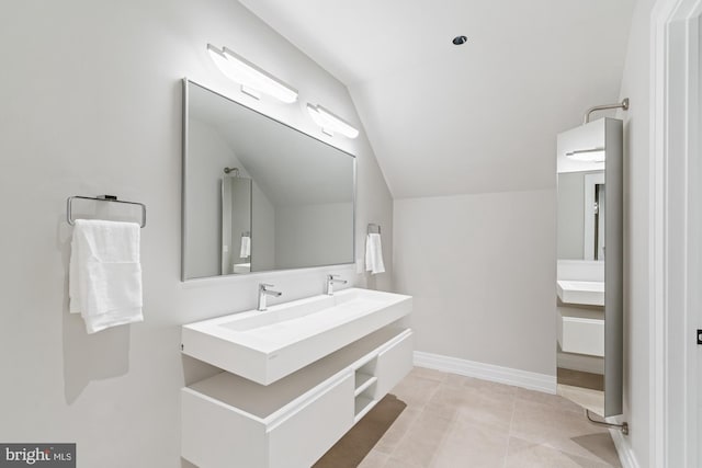 full bathroom with tile patterned floors, vanity, baseboards, and vaulted ceiling