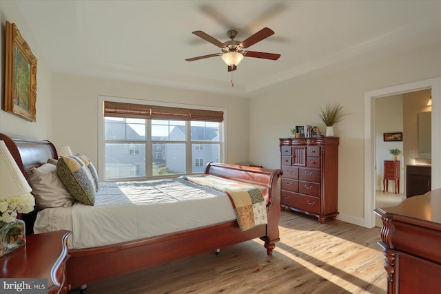 bedroom with light hardwood / wood-style floors, connected bathroom, and ceiling fan