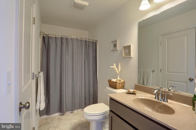 bathroom featuring toilet, walk in shower, vanity, and tile patterned flooring