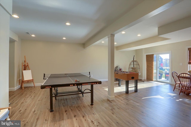 game room featuring beamed ceiling and light wood-type flooring