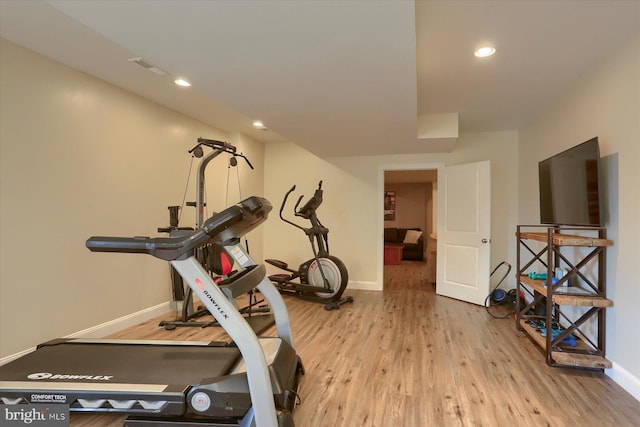 exercise room with light hardwood / wood-style flooring