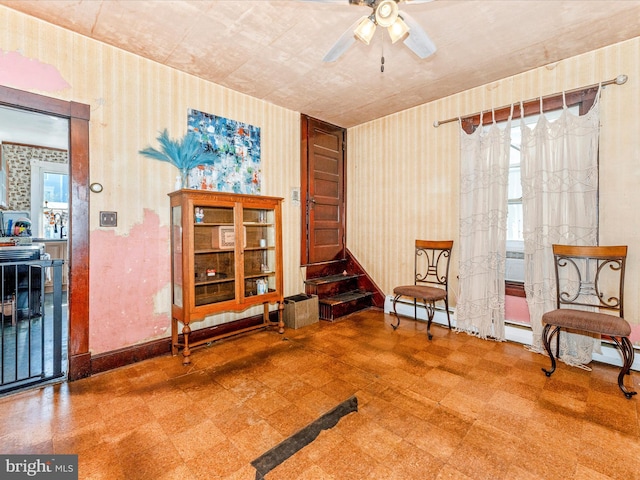 living area with ceiling fan and a healthy amount of sunlight