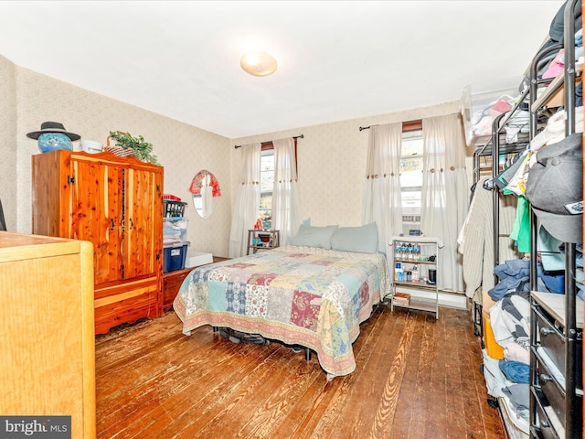 bedroom featuring multiple windows and dark hardwood / wood-style floors