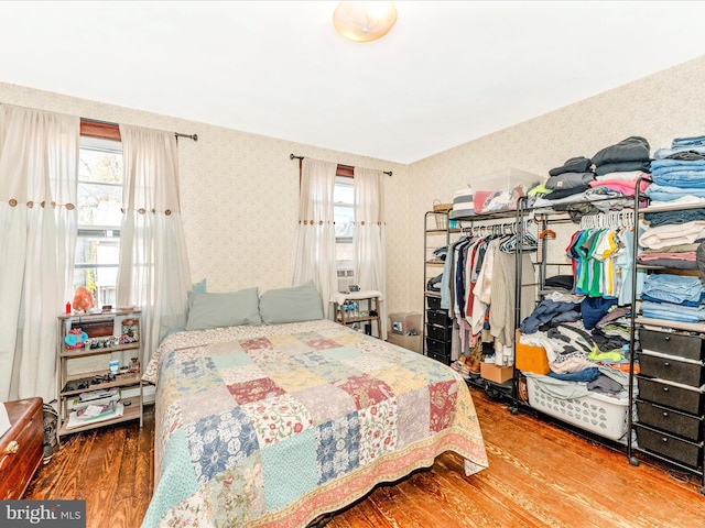 bedroom with multiple windows and wood-type flooring