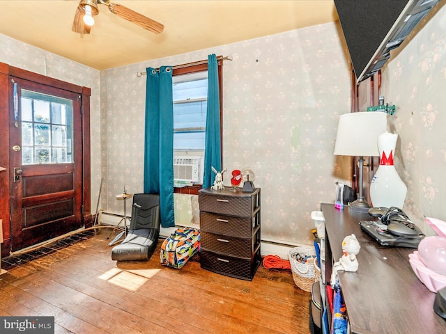 interior space featuring wood-type flooring, a baseboard radiator, and ceiling fan