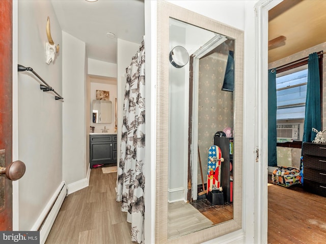 bathroom with vanity, hardwood / wood-style flooring, and baseboard heating