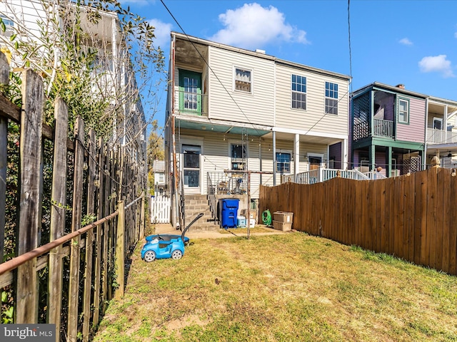 back of property featuring a yard and a balcony