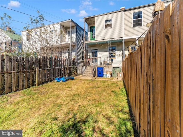 rear view of property with a yard and a balcony