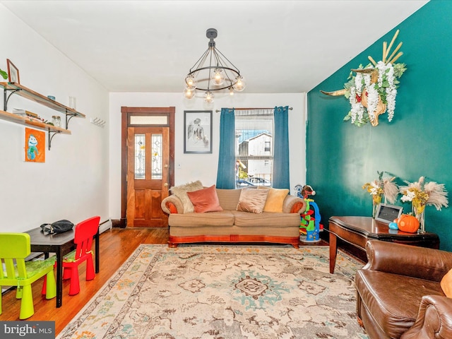 living room with a baseboard heating unit, hardwood / wood-style flooring, and a chandelier