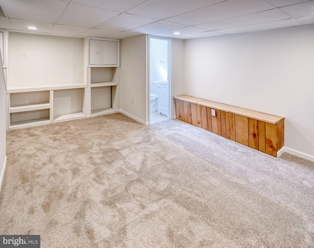 basement with a drop ceiling and light colored carpet