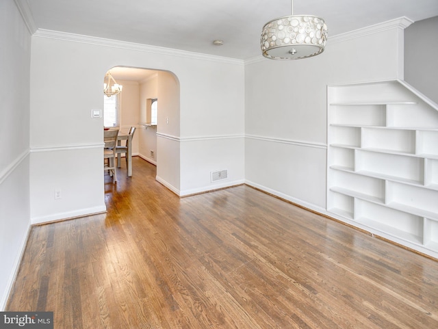 spare room with ornamental molding and hardwood / wood-style flooring