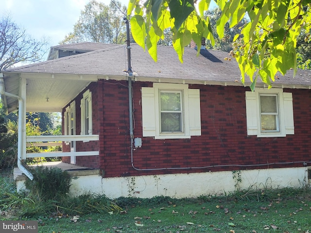view of side of home featuring covered porch