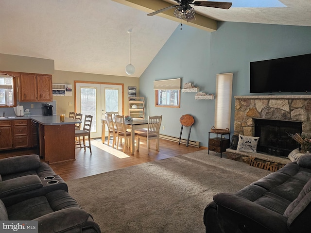 living room with a fireplace, plenty of natural light, ceiling fan, and light hardwood / wood-style flooring