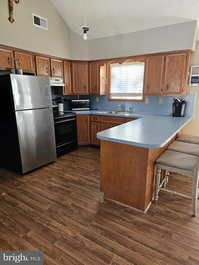 kitchen featuring black range with electric cooktop, stainless steel refrigerator, dark hardwood / wood-style floors, high vaulted ceiling, and kitchen peninsula