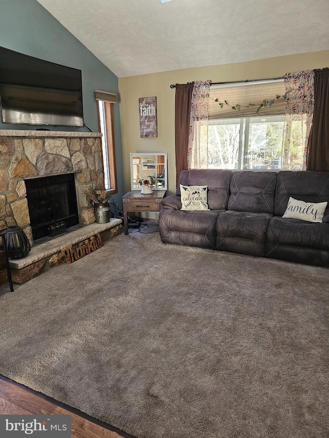 living room with carpet flooring, a fireplace, a textured ceiling, and vaulted ceiling