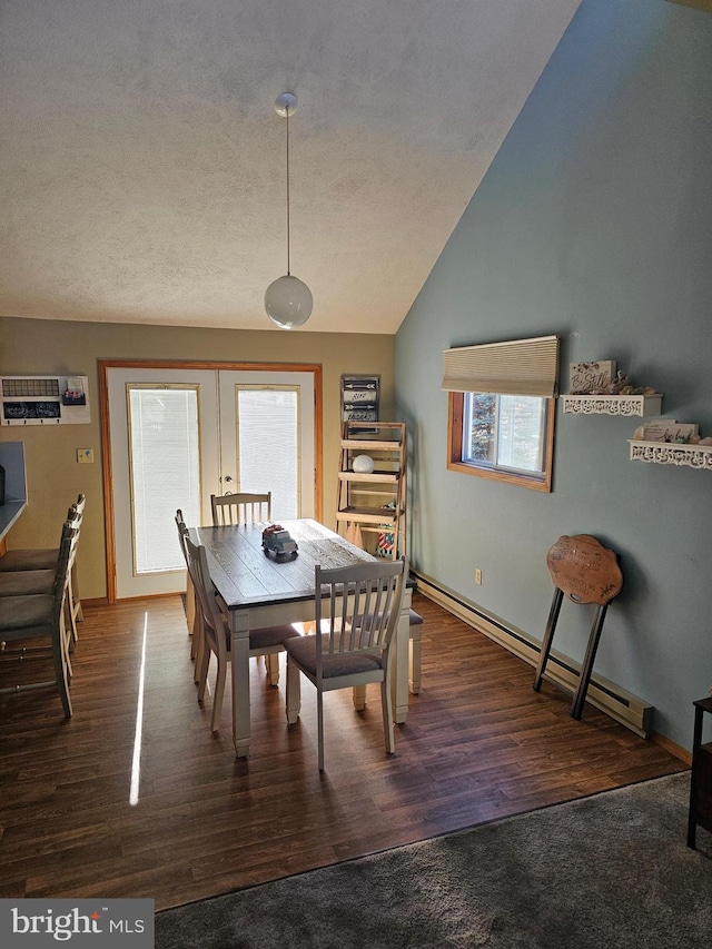 dining area with lofted ceiling, a textured ceiling, dark hardwood / wood-style floors, and a baseboard heating unit