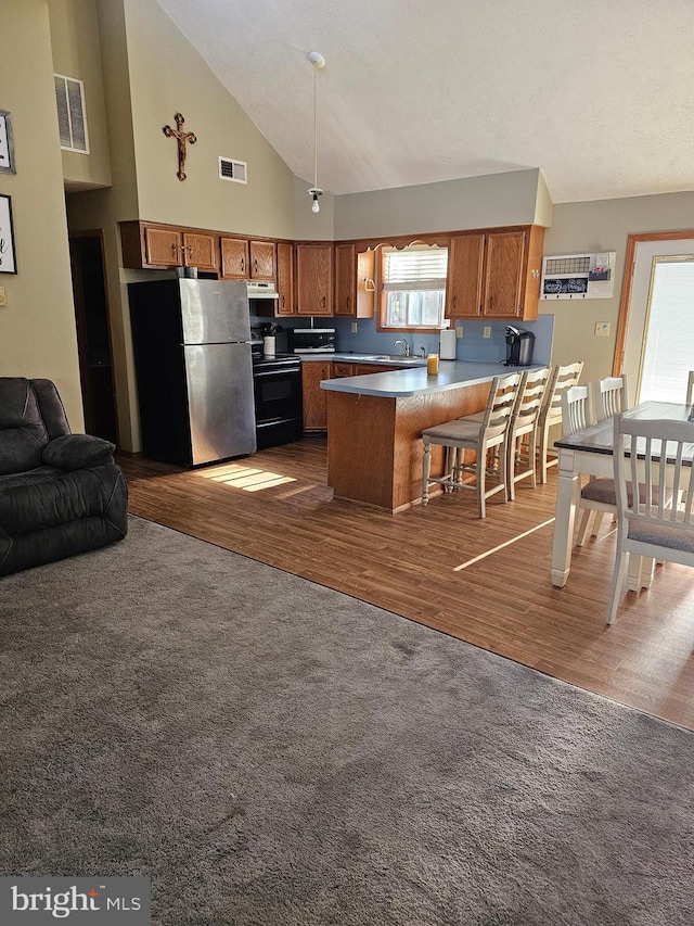 kitchen featuring high vaulted ceiling, black range with electric stovetop, stainless steel refrigerator, and dark hardwood / wood-style floors