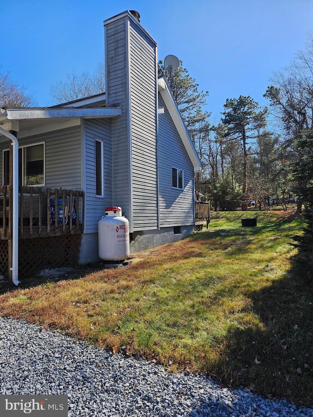 view of property exterior featuring a lawn and a wooden deck