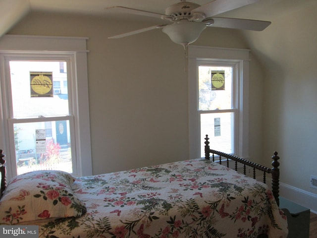 bedroom featuring vaulted ceiling, multiple windows, and ceiling fan