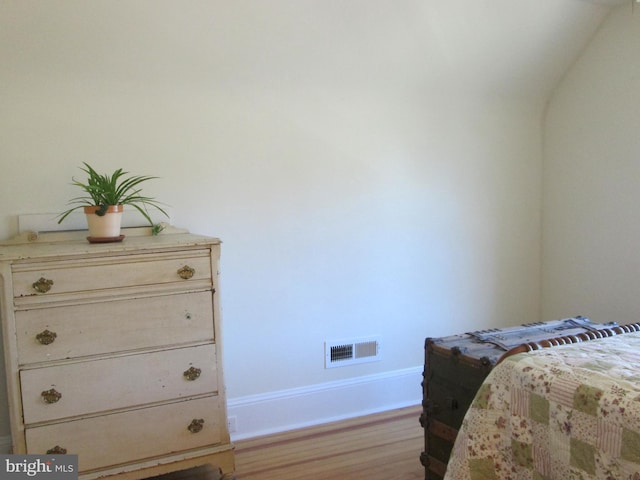 bedroom with lofted ceiling and light wood-type flooring