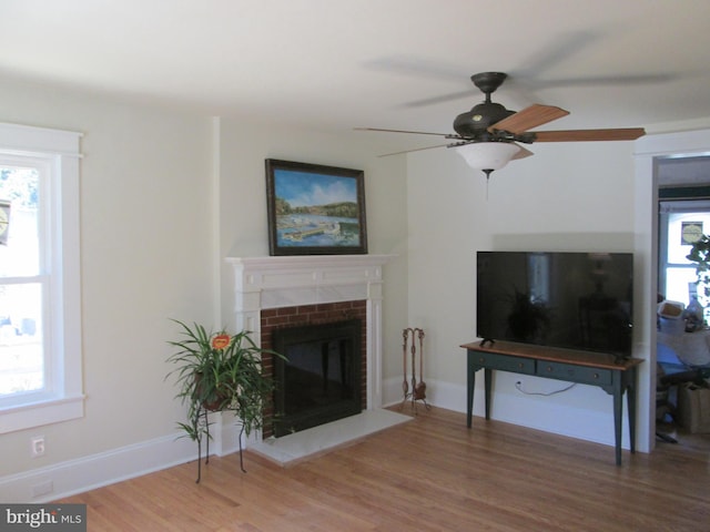 living room featuring hardwood / wood-style flooring, a fireplace, and ceiling fan