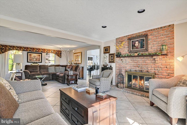 living room featuring light tile patterned floors, a textured ceiling, a brick fireplace, and crown molding