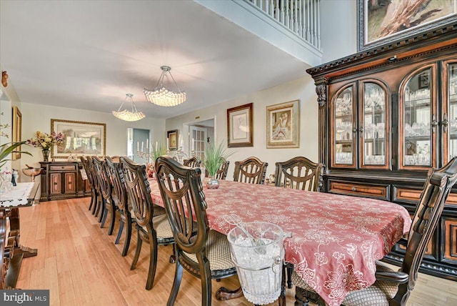 dining room featuring light wood-type flooring and a notable chandelier