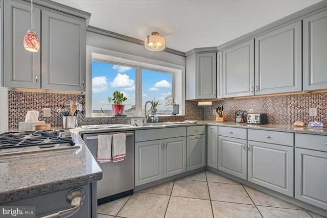 kitchen featuring light tile patterned floors, stainless steel appliances, light stone counters, and gray cabinetry