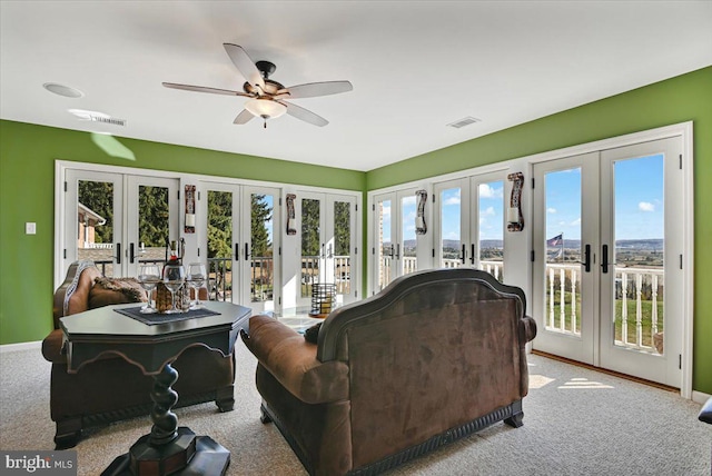 living room featuring plenty of natural light, ceiling fan, light carpet, and french doors