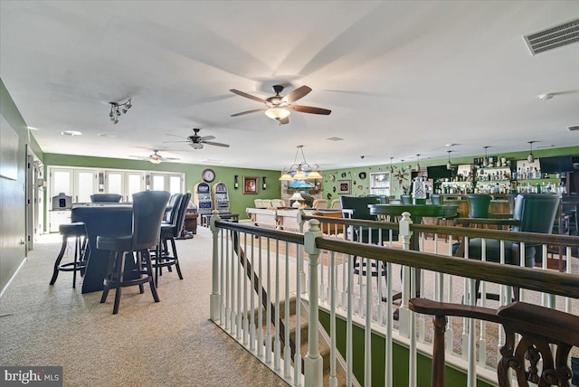 exterior space with bar, ceiling fan, and light colored carpet