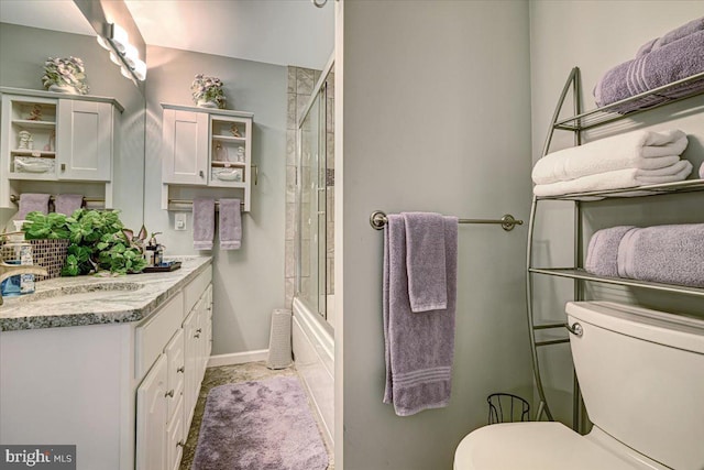 full bathroom featuring vanity, toilet, and bath / shower combo with glass door