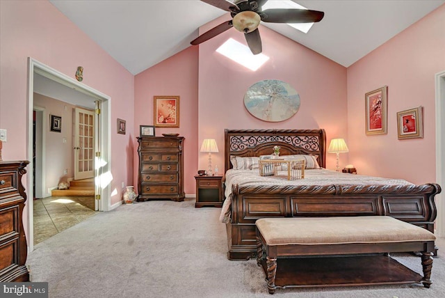 carpeted bedroom featuring a skylight, ceiling fan, and high vaulted ceiling