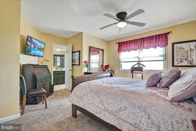 bedroom featuring carpet floors, ensuite bathroom, and ceiling fan